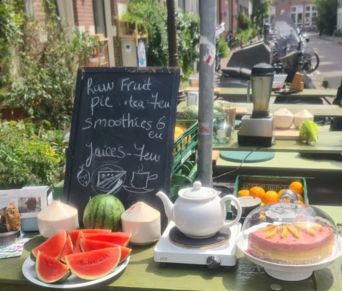 Outdoor pop-up stand with watermelon, coconuts, and a chalkboard menu