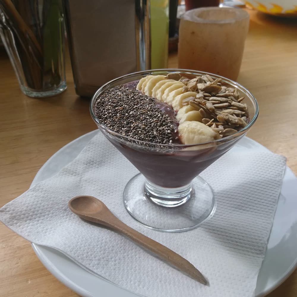 An acai bowl topped with banana, chia seeds, and sunflower seeds